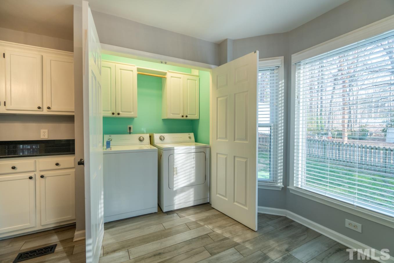 5525 Banwell Place Raleigh, NC 27613 - Photo 16 of 39 a utility room with cabinets washer and dryer