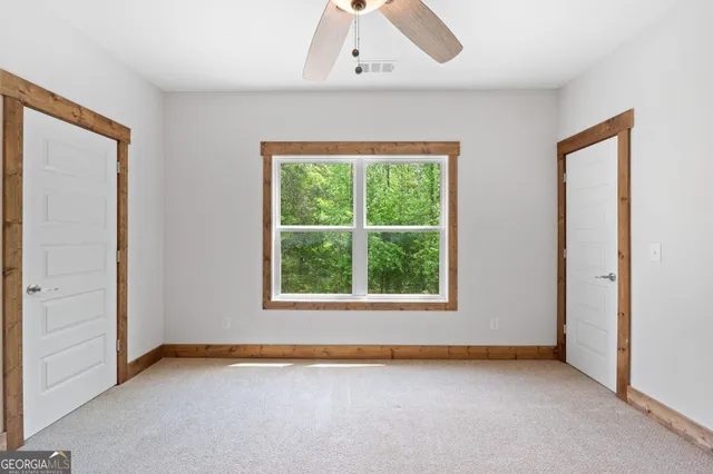a view of a hallway with wooden floor and a living room