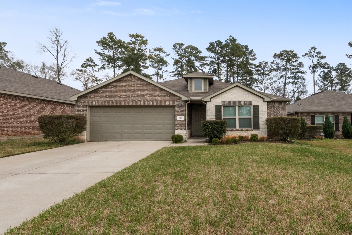 175 Courageous Side Way Magnolia, TX 77354 - Photo 1 of 28 a front view of a house with a garden and trees