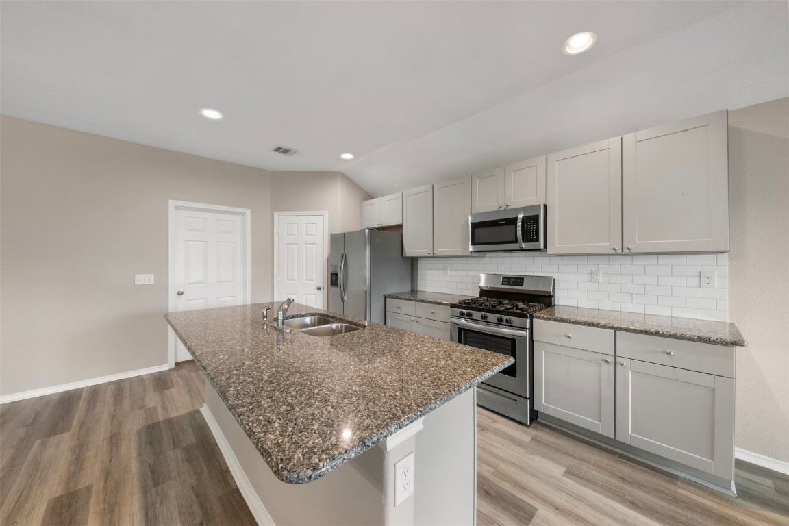 175 Courageous Side Way Magnolia, TX 77354 - Photo 11 of 28 a kitchen with stainless steel appliances granite countertop a sink stove and cabinets