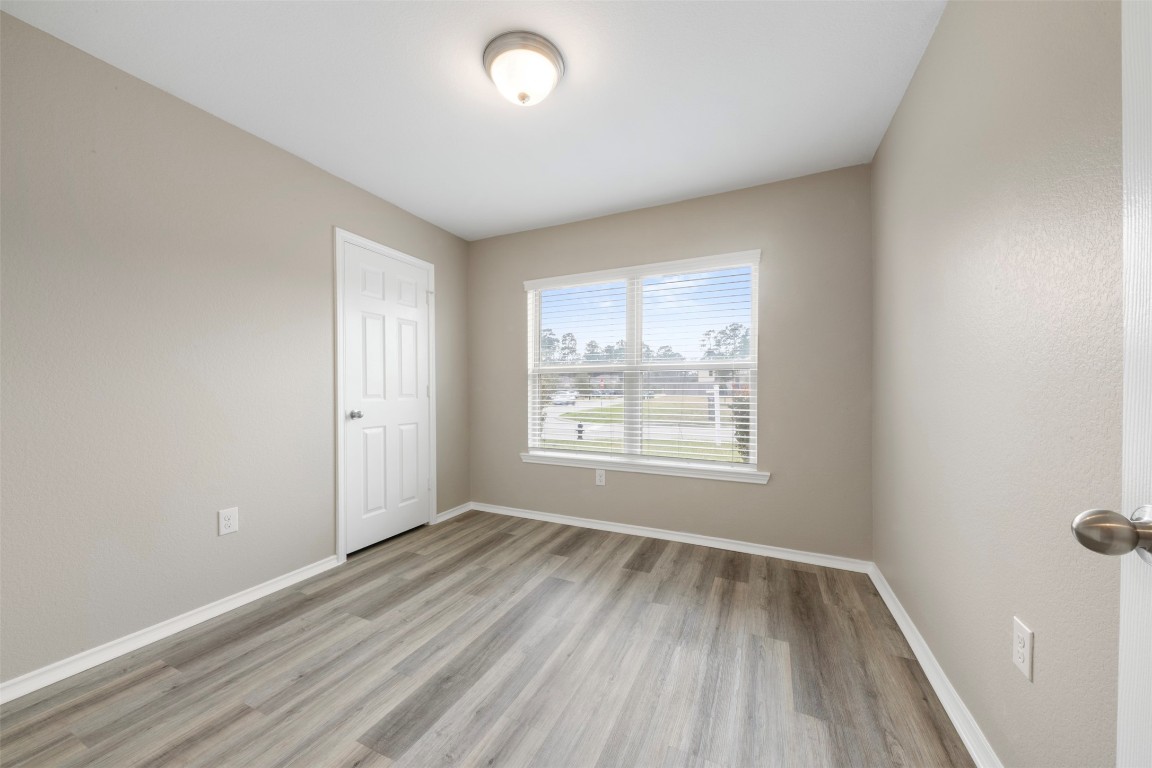 175 Courageous Side Way Magnolia, TX 77354 - Photo 24 of 28 an empty room with wooden floor and windows