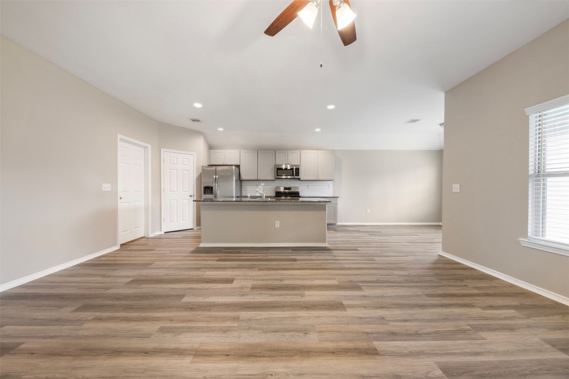 175 Courageous Side Way Magnolia, TX 77354 - Photo 6 of 28 a view of kitchen with kitchen island stainless steel appliances wooden floor cabinets and a window