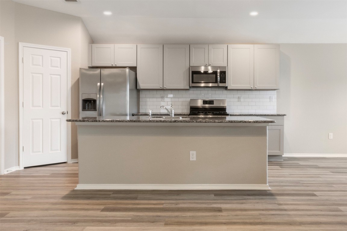 175 Courageous Side Way Magnolia, TX 77354 - Photo 8 of 28 a kitchen with kitchen island stainless steel appliances granite countertop a stove a sink and a refrigerator