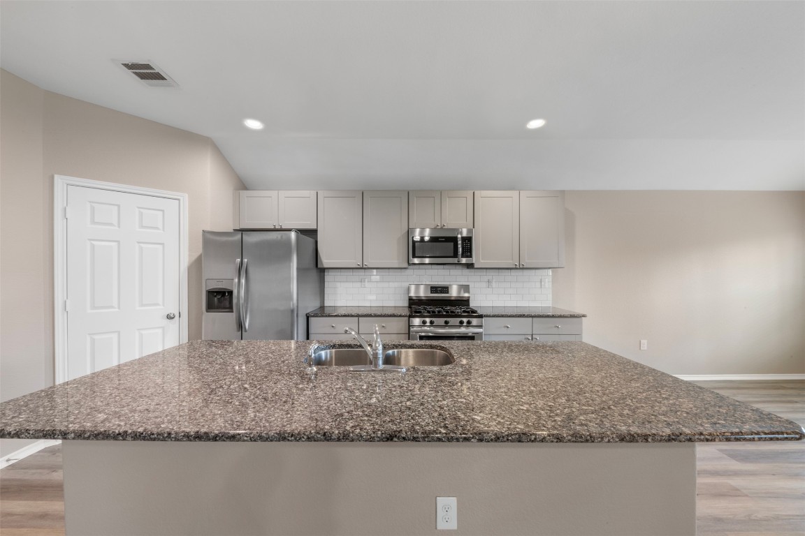 175 Courageous Side Way Magnolia, TX 77354 - Photo 9 of 28 a kitchen with stainless steel appliances granite countertop a sink stove and refrigerator