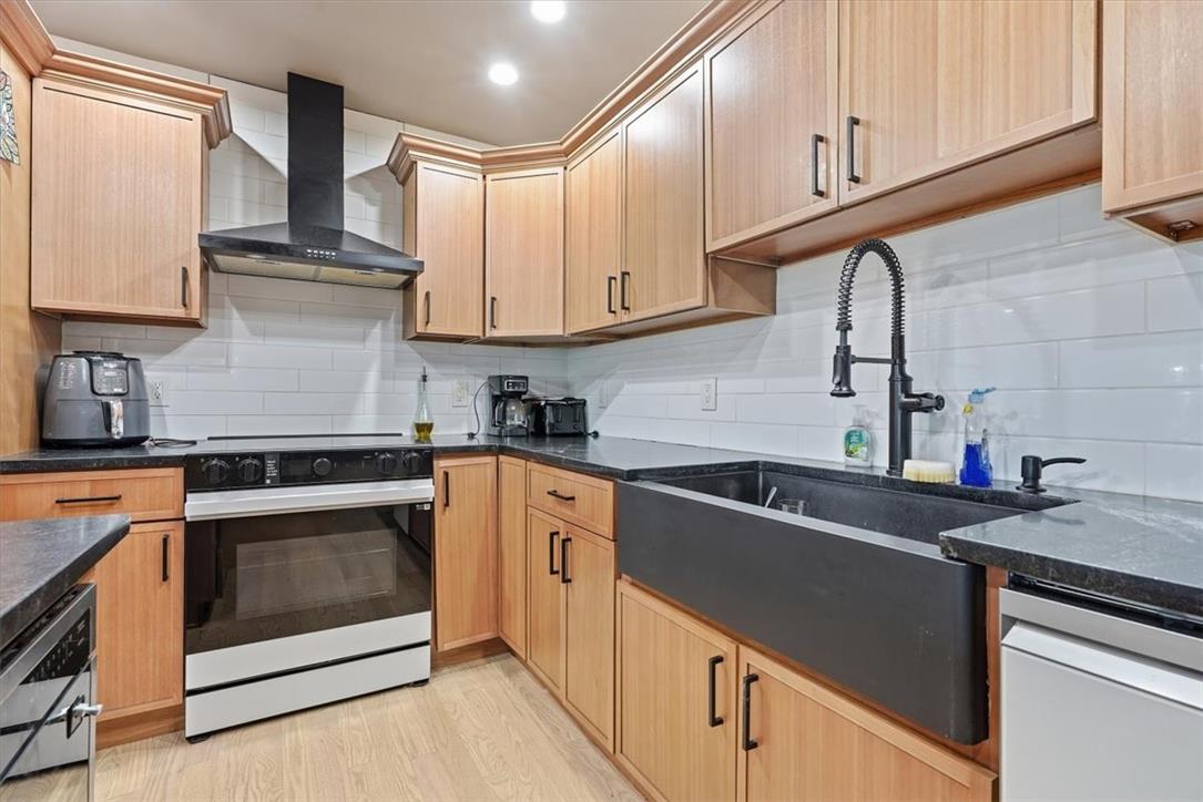 2930 Oakland Road Bethlehem, PA 18017 - Photo 53 of 55 Warm wood cabinetry pairs with dark stone counters and a farmhouse sink in this kitchen.