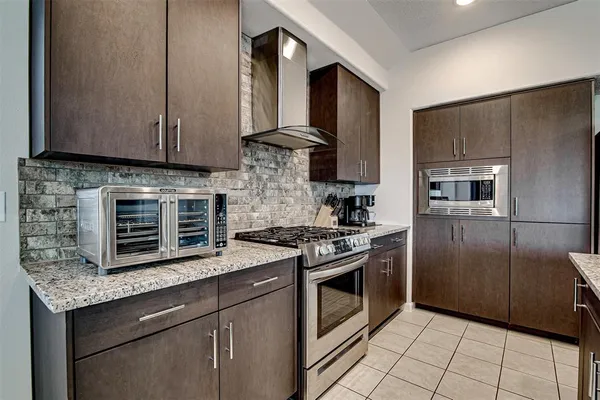 a kitchen with stainless steel appliances granite countertop a stove a refrigerator and a microwave