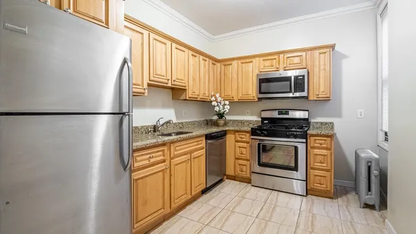 a kitchen with stainless steel appliances granite countertop a refrigerator stove a sink and a microwave