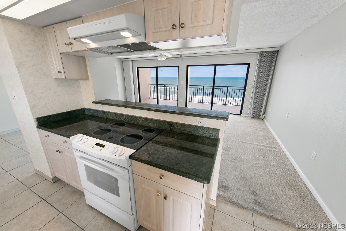 4435 South Atlantic Avenue, Unit 712 Ponce Inlet, FL 32127 - Photo 8 of 28 a kitchen with granite countertop a stove and a white cabinets