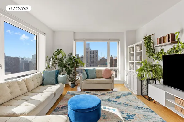 a living room with furniture flat screen tv and a large window