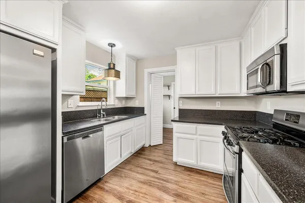 a kitchen with stainless steel appliances granite countertop a sink stove and refrigerator