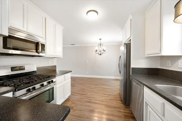 a kitchen with granite countertop a sink cabinets and stainless steel appliances