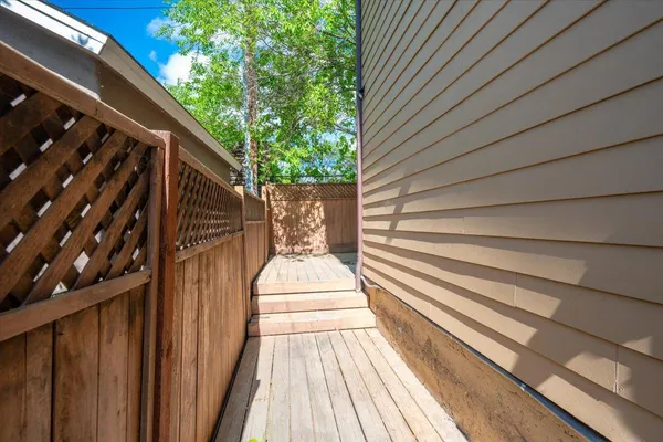 a view of balcony with wooden floor and fence and a potted plant