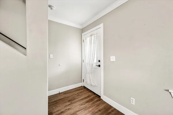 a view of an empty room with wooden floor