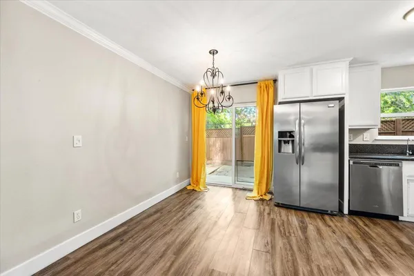 a kitchen with a refrigerator and a wooden floor