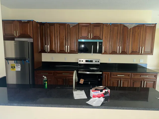 a kitchen with stainless steel appliances granite countertop a stove refrigerator and cabinets