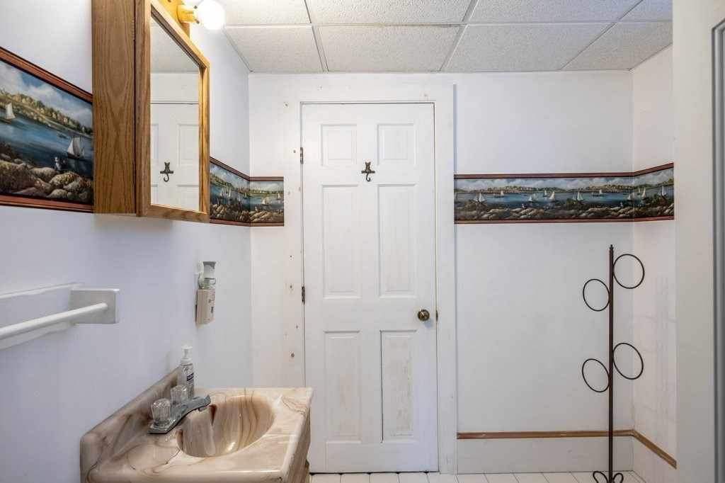 164 Main Street Fairhaven, MA 02719 - Photo 23 of 42 a bathroom with a granite countertop sink a mirror and shower