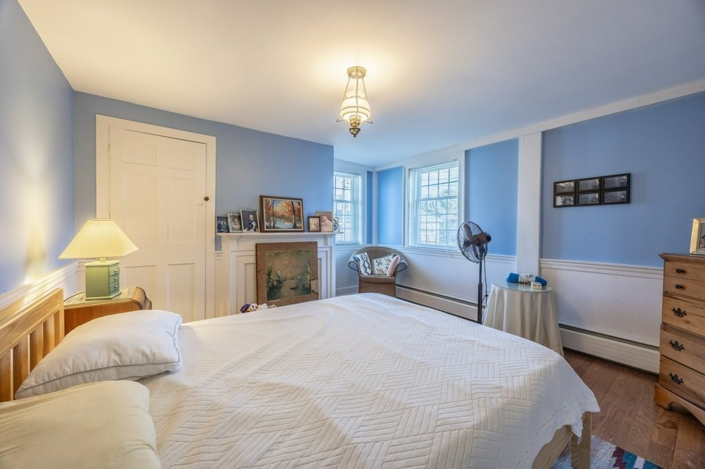 164 Main Street Fairhaven, MA 02719 - Photo 25 of 42 a bedroom with a bed and a chandelier