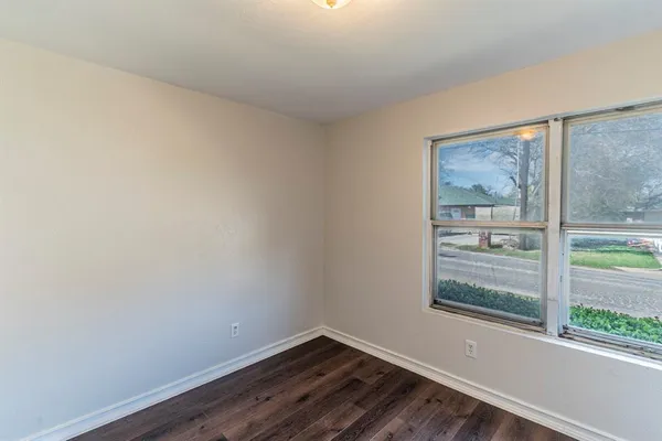 a view of a small space with wooden floor and a window