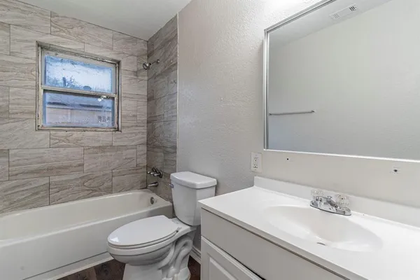 a white toilet sitting next to a bath tub