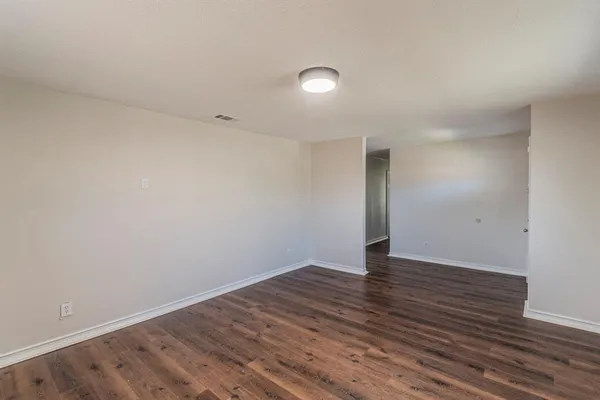 a view of an empty room with wooden floor