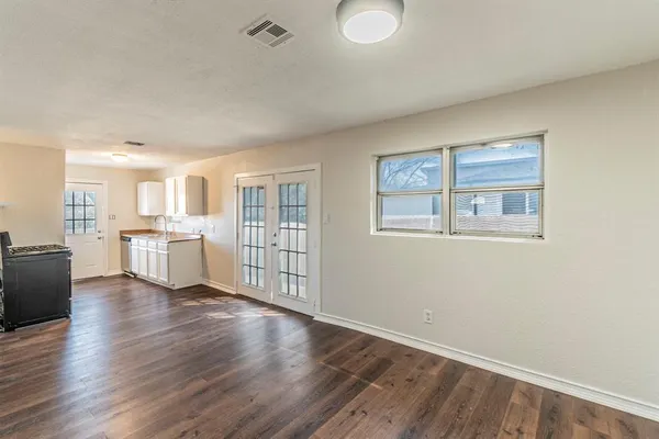 a view of a kitchen with wooden floor and windows