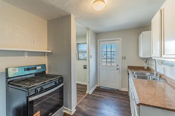 a kitchen with granite countertop a stove and a refrigerator