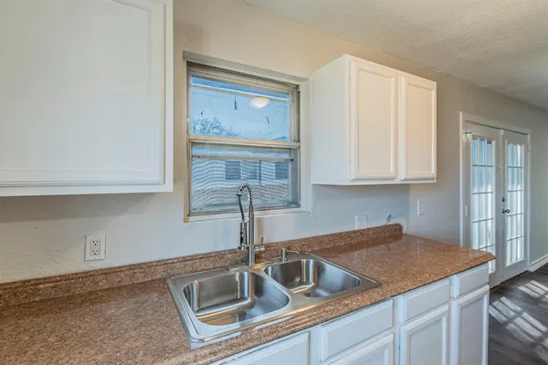 a kitchen with granite countertop a sink and cabinets