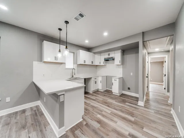 a kitchen with kitchen island a sink stove and wooden floor