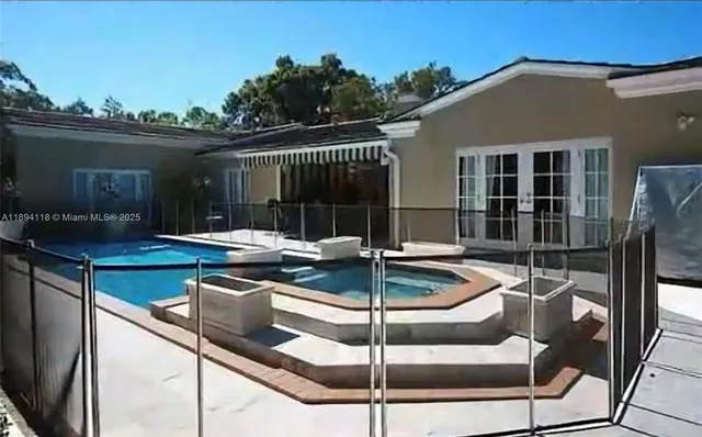 a patio with table and chairs and potted plants