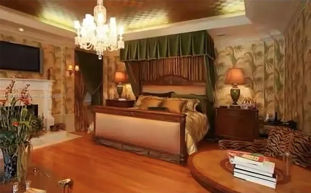 a bedroom with bed and a flat tv screen on dresser