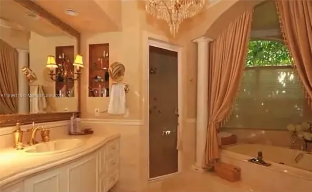 a bathroom with a tub sink and mirror