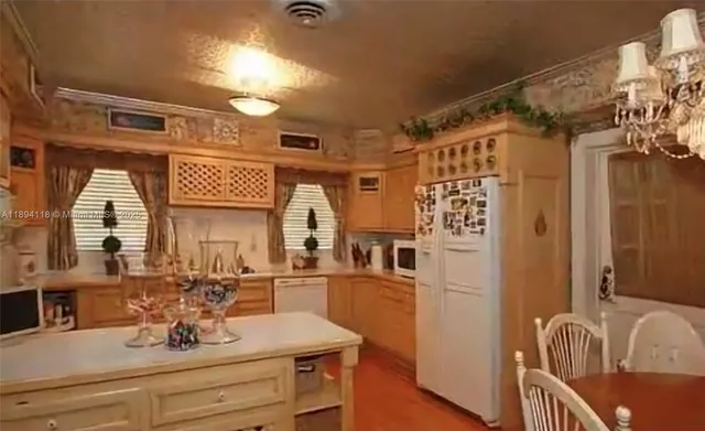 a view of a kitchen with sink and refrigerator