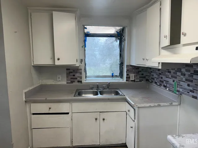 a kitchen with granite countertop white cabinets and white appliances