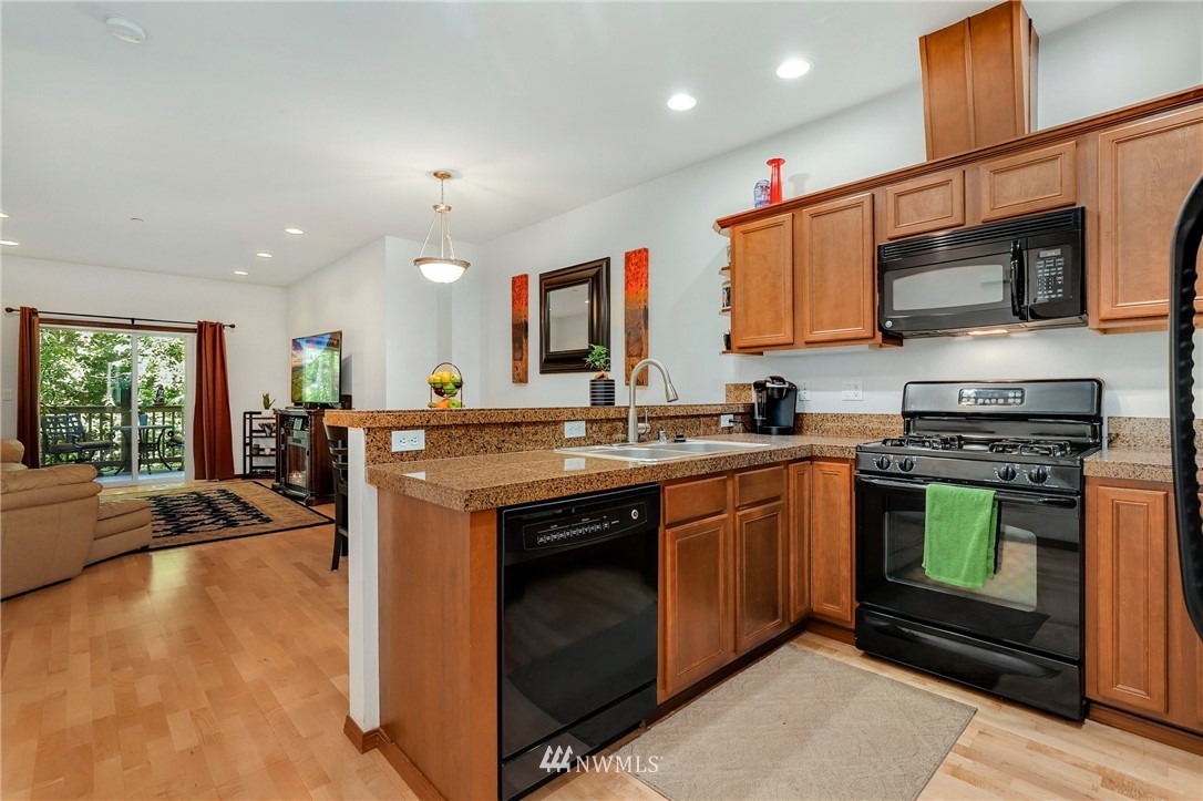 21351 11th Drive Southeast Bothell, WA 98021 - Photo 15 of 33 a kitchen with stainless steel appliances granite countertop a stove a sink and a microwave