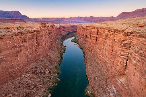 1140 Julie Road Henderson, NV 89002 - Photo 20 of 38 The Colorado river carves a striking path through towering, rugged canyon walls, stretching into the distant horizon.