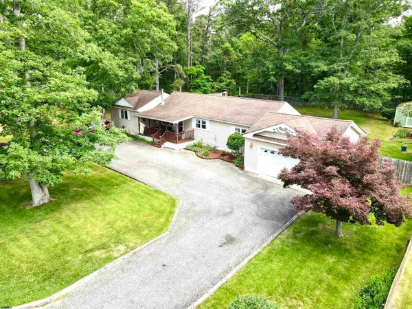 an aerial view of residential house with outdoor space and trees all around