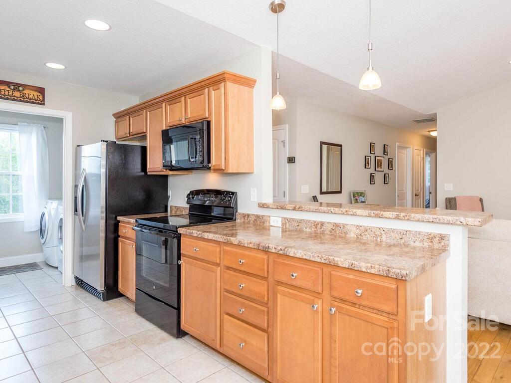 243 Scarlett Ridge Drive Marshall, NC 28753 - Photo 18 of 36 a kitchen with stainless steel appliances granite countertop a stove a sink and a refrigerator