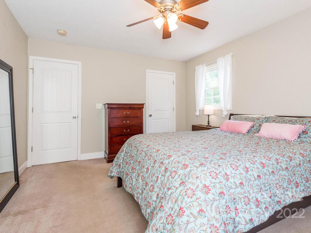 243 Scarlett Ridge Drive Marshall, NC 28753 - Photo 23 of 36 a bedroom with a bed and a chandelier