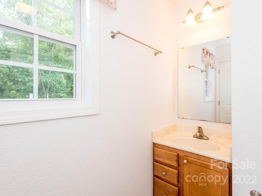 243 Scarlett Ridge Drive Marshall, NC 28753 - Photo 25 of 36 a bathroom with a granite countertop sink a mirror and a shower