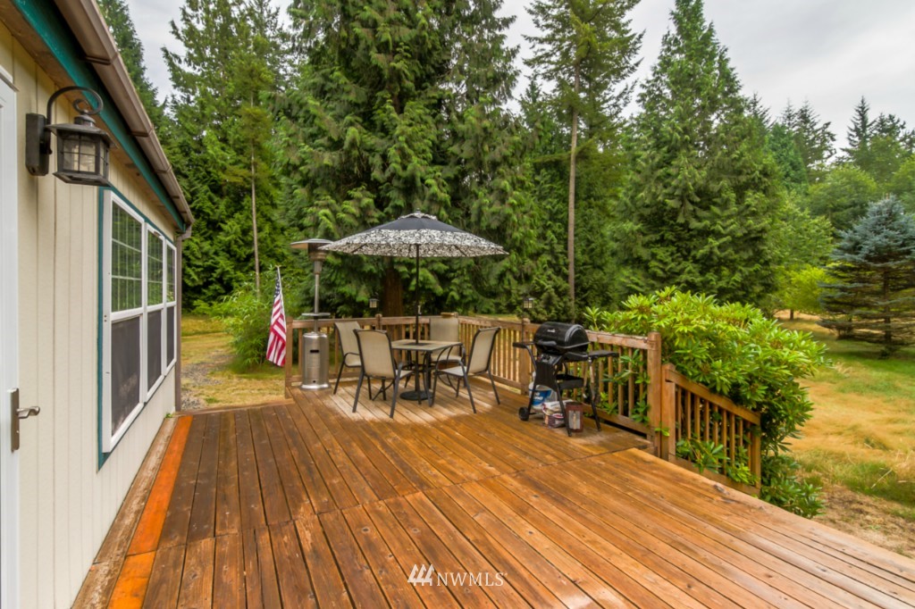 3554 Loomis Trail Road Blaine, WA 98230 - Photo 16 of 23 a view of a patio with table and chairs under an umbrella with wooden floor