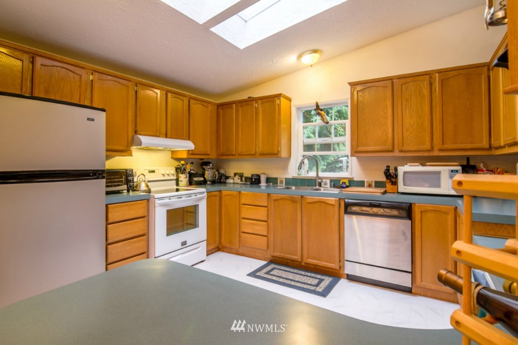 3554 Loomis Trail Road Blaine, WA 98230 - Photo 4 of 23 a kitchen with granite countertop wooden cabinets a stove a sink a dining table and chairs