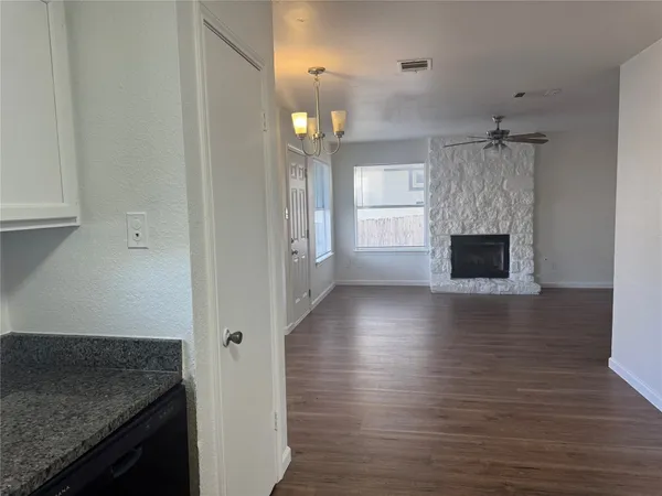 an empty room with wooden floor and a fireplace