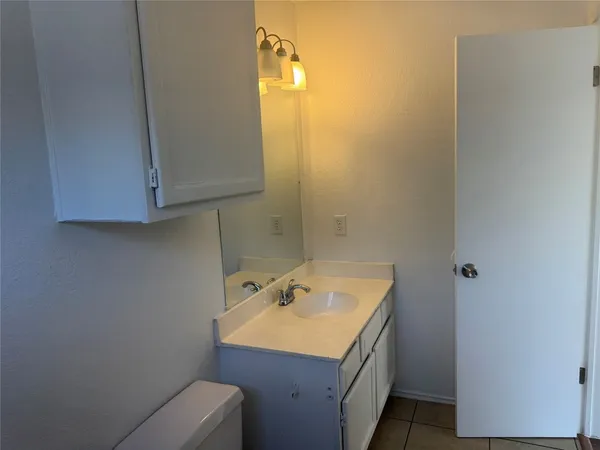 a bathroom with a sink toilet and mirror