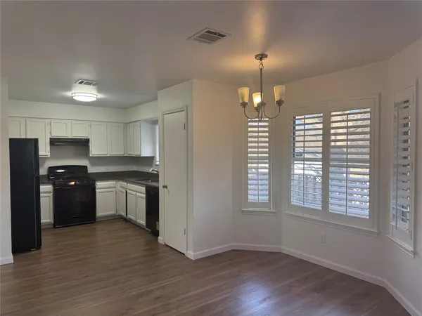 a kitchen with granite countertop a refrigerator and a stove top oven
