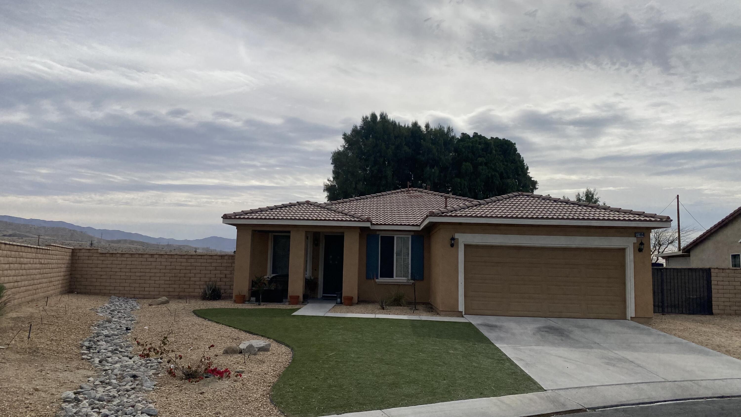 37894 Medway Street Indio, CA 92203 - Photo 1 of 27 a front view of a house with a garden and trees