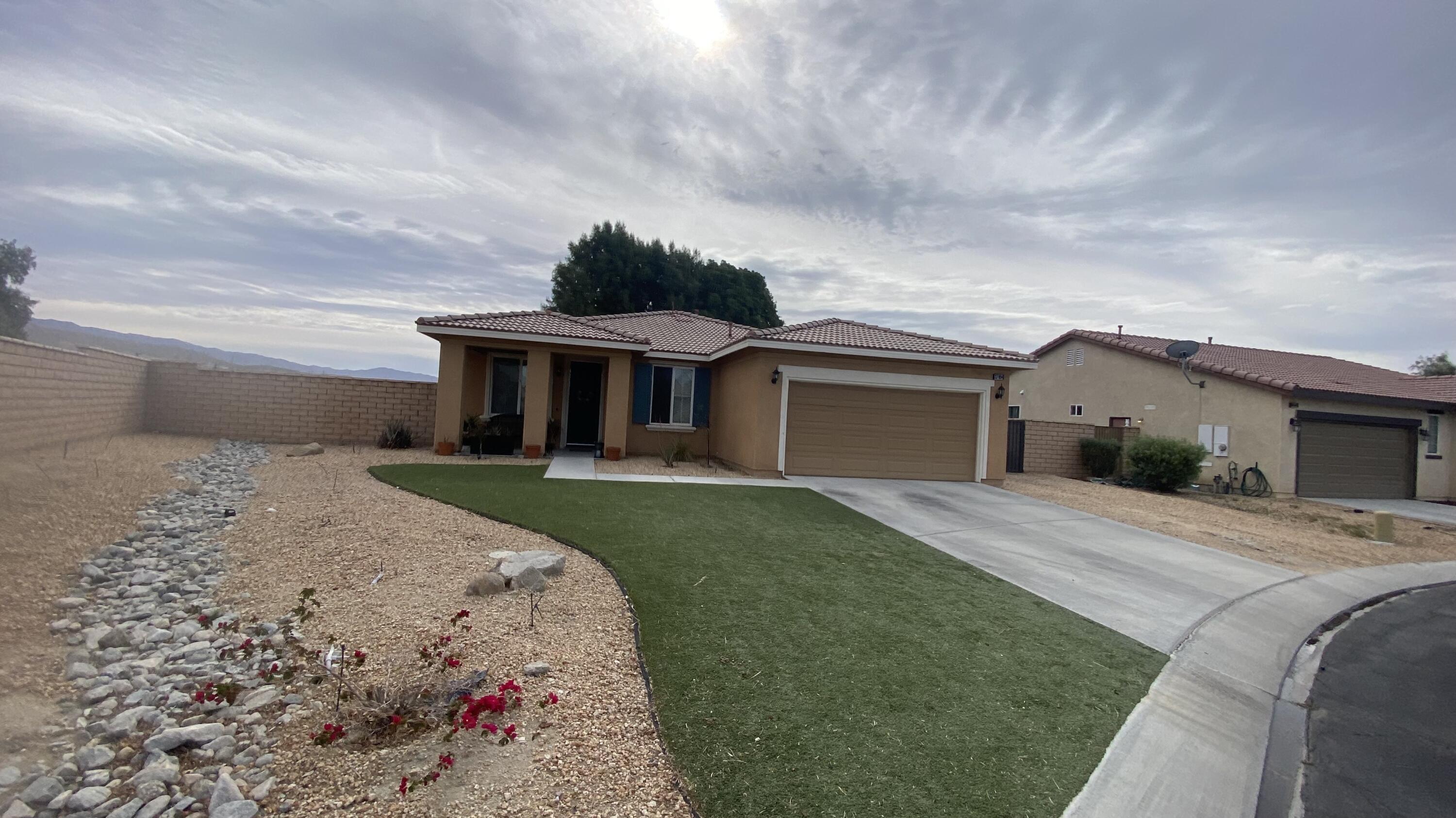37894 Medway Street Indio, CA 92203 - Photo 2 of 27 a front view of a house with a garden