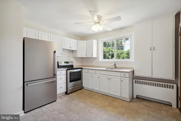 a kitchen with granite countertop stainless steel appliances a sink cabinets and a window