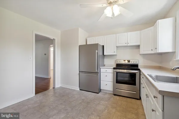 a kitchen with a refrigerator stove and white cabinets