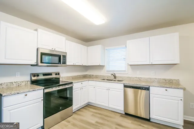 a kitchen with white cabinets stainless steel appliances and sink