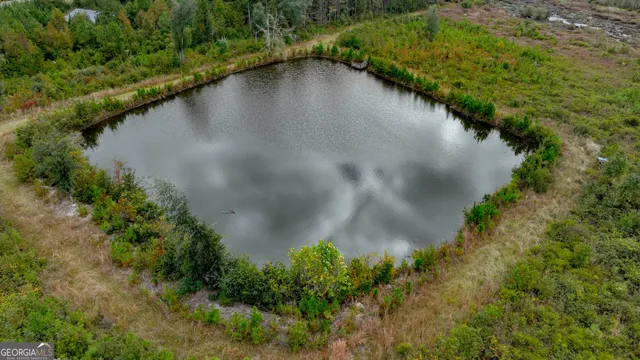 a view of a lake with a yard and trees all around